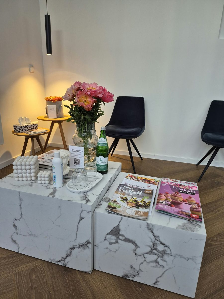 Gemütlicher Wartebereich mit Marmortischen und Blumen